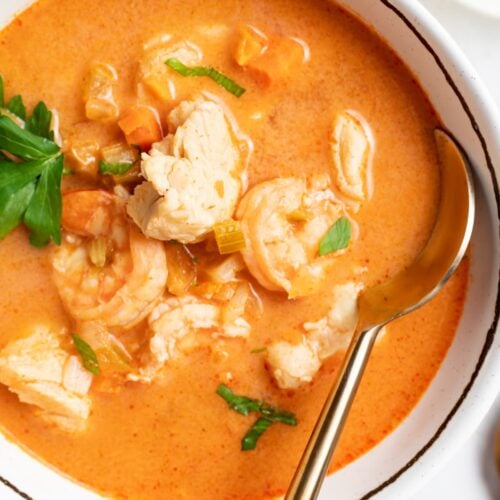 overhead image of seafood soup in a bowl with parsley on top