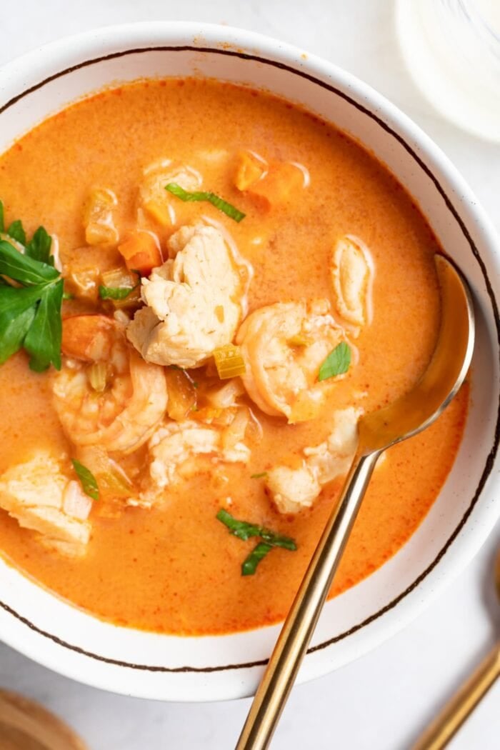 overhead image of seafood soup in a bowl with parsley on top