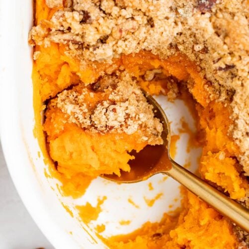 close up overhead image of sweet potato souffle with a spoon in it.