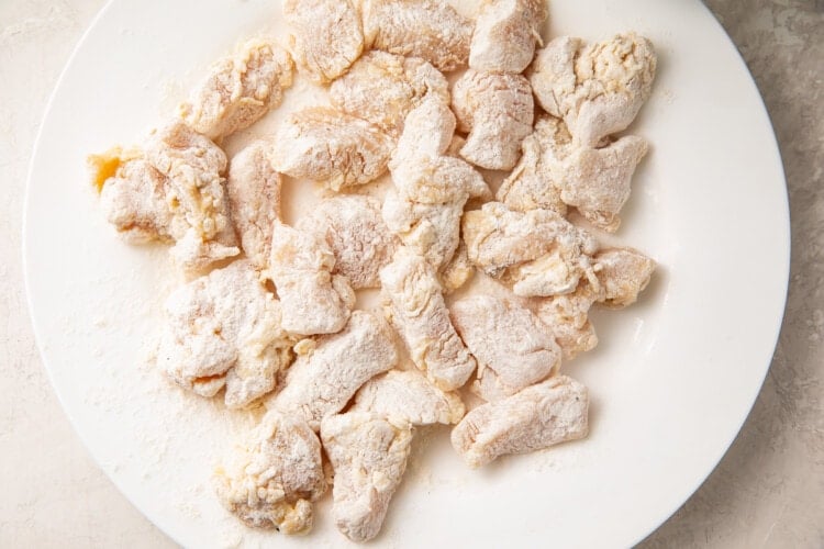 Flour-coated chicken pieces on a plate