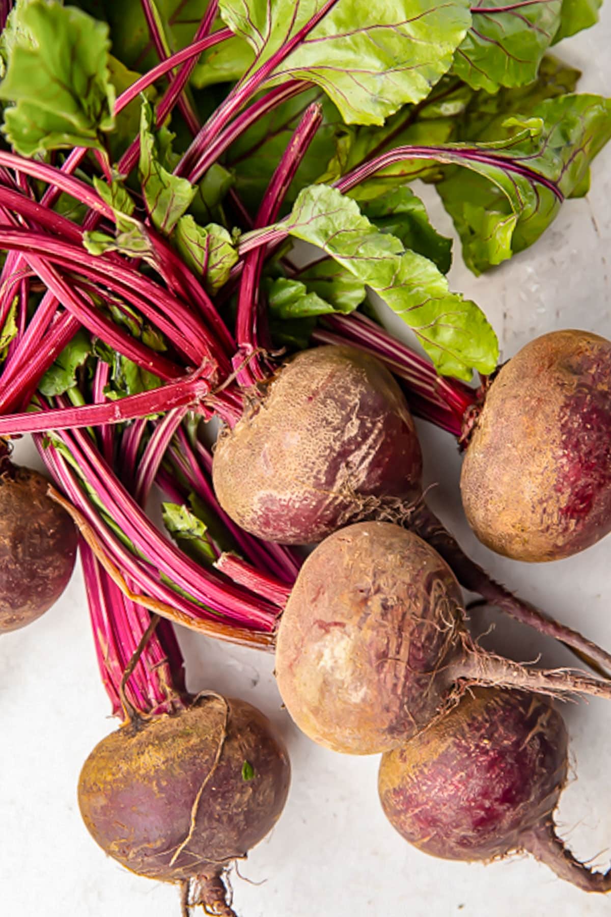 Fresh beets with stems and leaves attached.