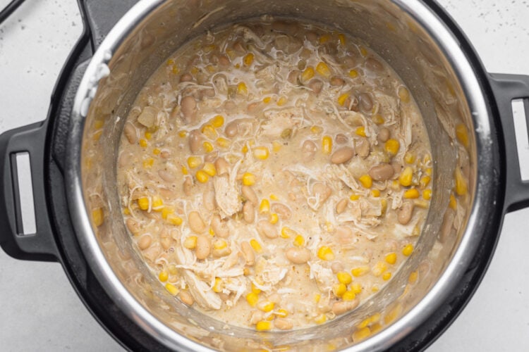 Creamy Instant Pot white chicken chili with shredded chicken in the bottom of an Instant Pot.