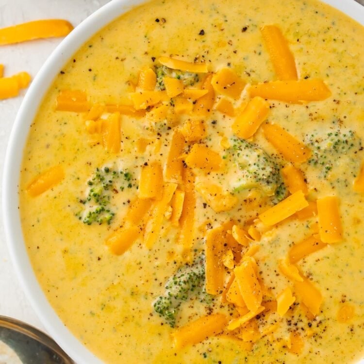 Overhead photo of keto broccoli cheese soup in a white bowl on a white table