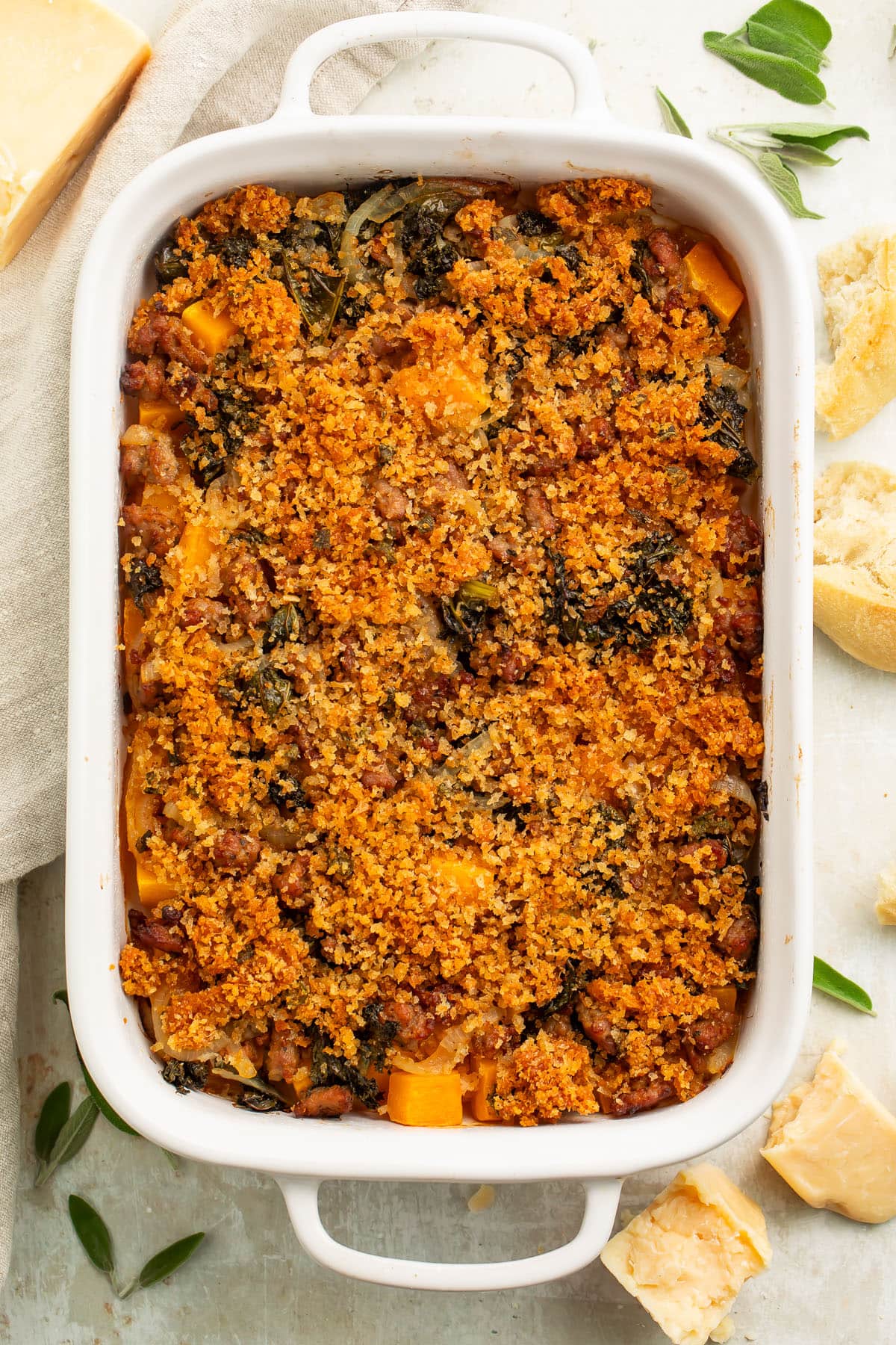 Overhead view of a large white casserole dish holding a butternut squash casserole topped with breadcrumbs.