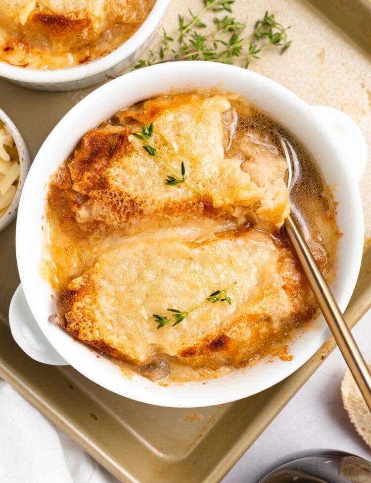 Overhead image of instant pot french onion soup in a bowl with fresh thyme on top