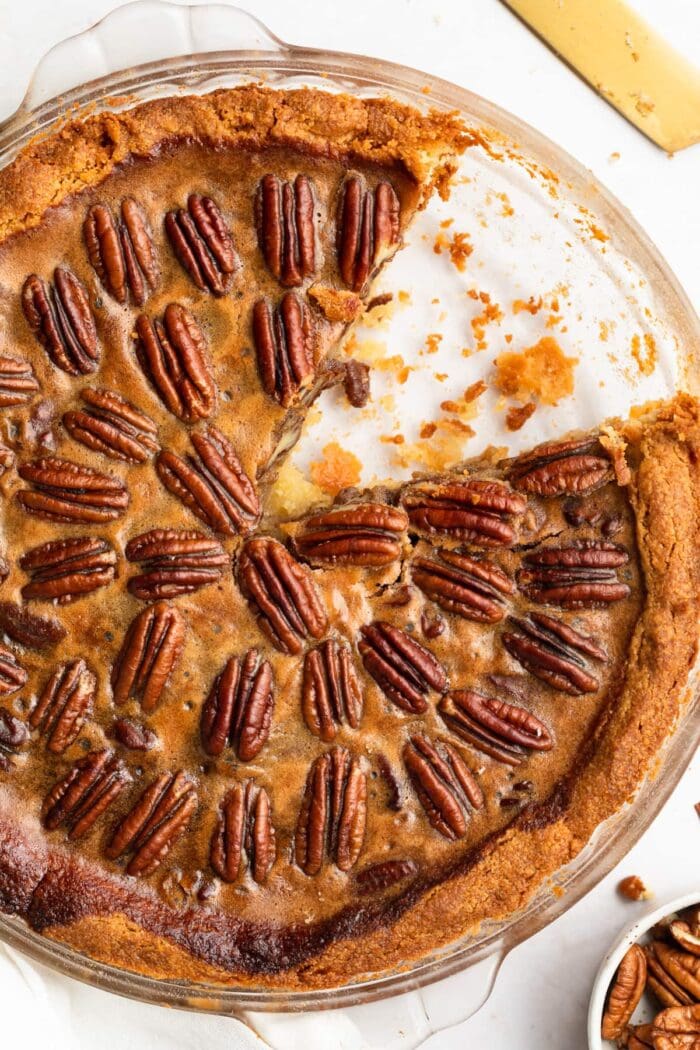 keto pecan pie in a pie dish with a slice removed