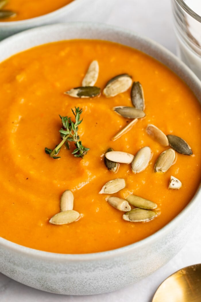 sweet potato soup in a bowl with pumpkin seeds on top