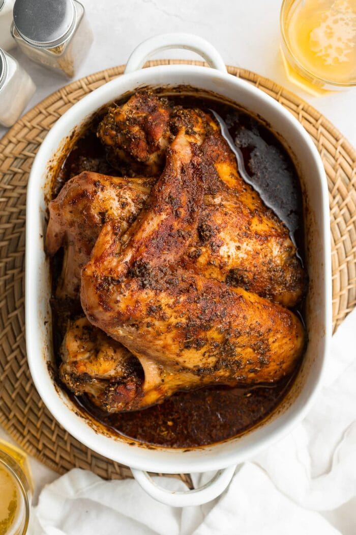 overhead image of baked turkey wings in a baking dish with beer on the side