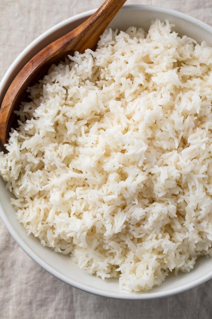 Overhead view of a large bowl of Instant Pot basmati rice with a wooden spoon on a table