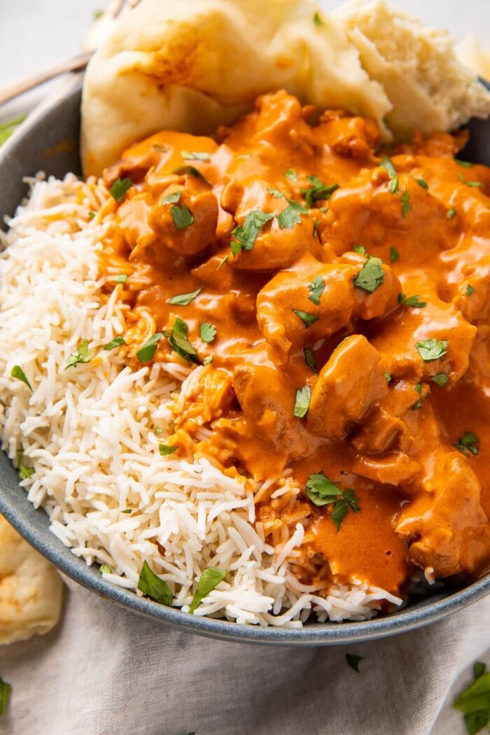 Instant Pot butter chicken, steamed basmati rice, and naan in a large grey bowl