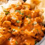 Instant Pot butter chicken in a large bowl with steamed rice and naan