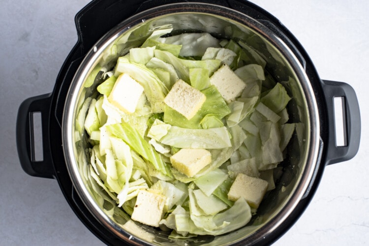 Roughly chopped cabbage, diced onion, and sliced butter in Instant Pot