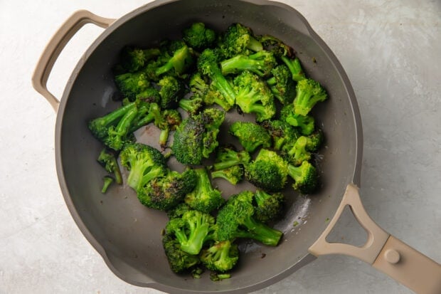 Sauteed broccoli in a large grey skillet