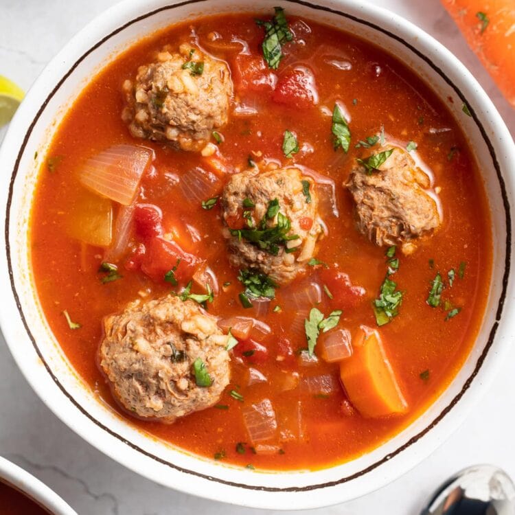 overhead image of albondigas soup in a bowl with fresh cilantro on top