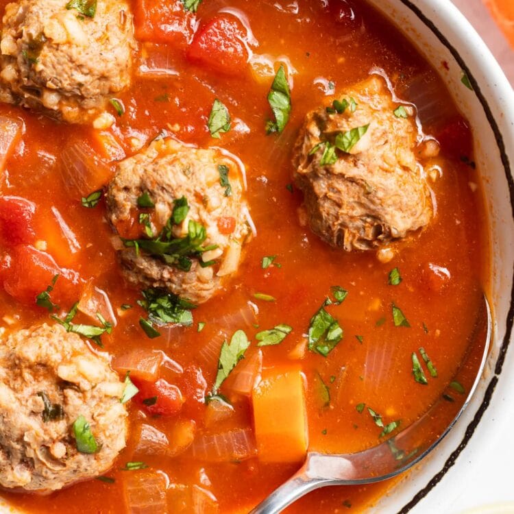 close up image of albondigas soup in a bowl with a spoon