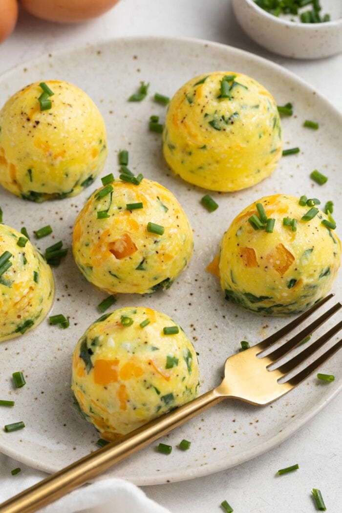 instant pot egg bites on a plate with fresh chopped chives on top