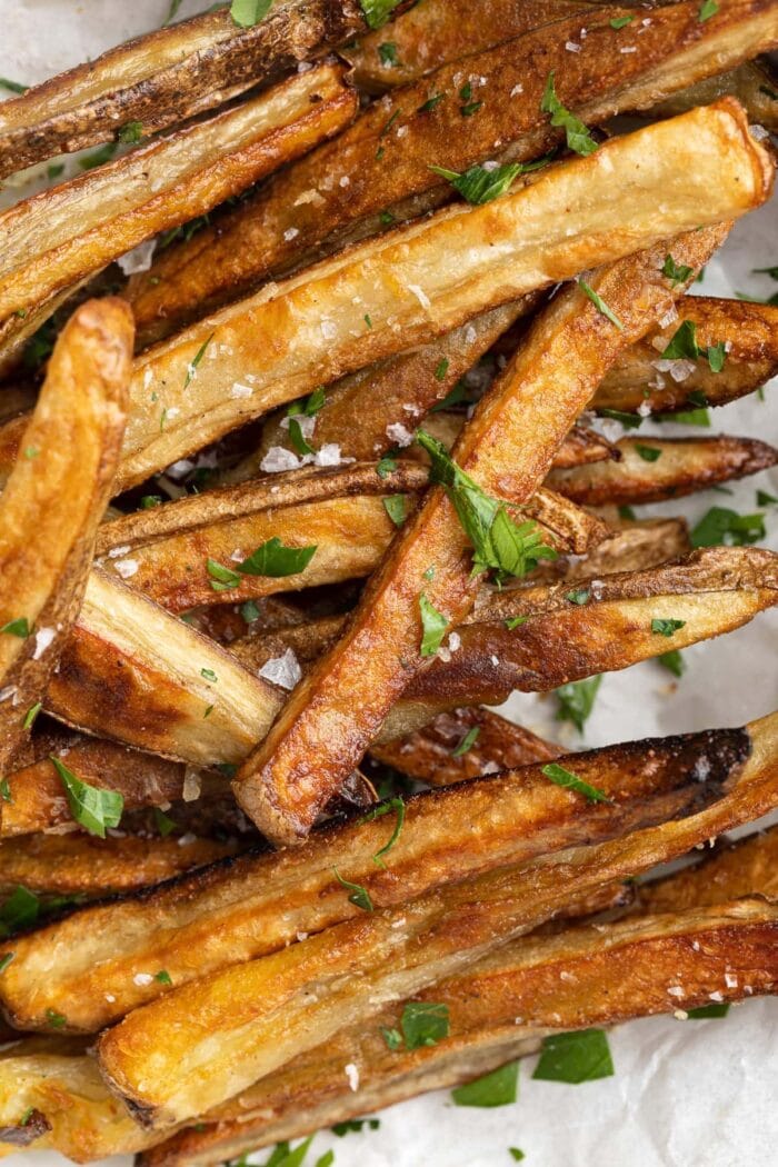 closeup image of parmesan truffle fries with fresh parsley on top