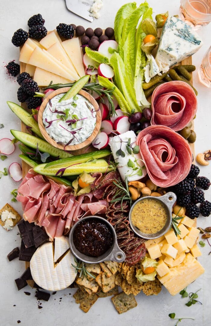 Overhead view of a keto charcuterie board with cheese, meat, nuts, veggies, and dips
