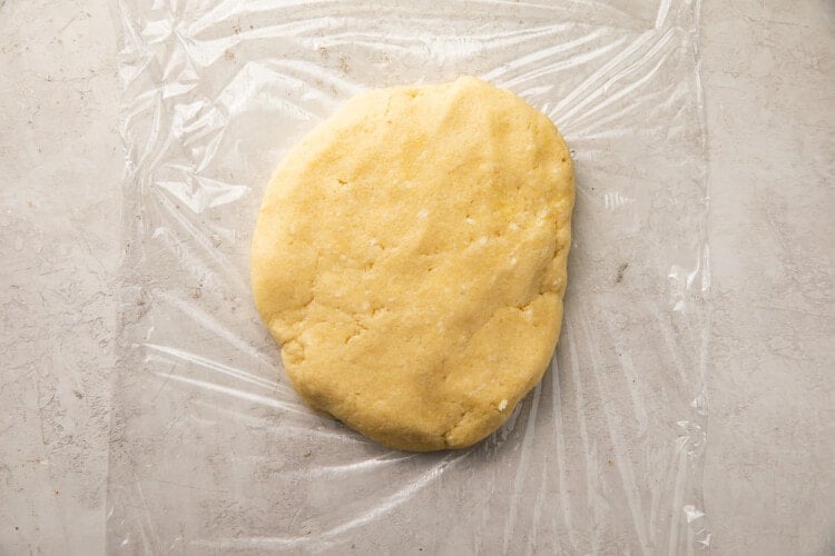 Ball of keto pie crust dough on plastic wrap