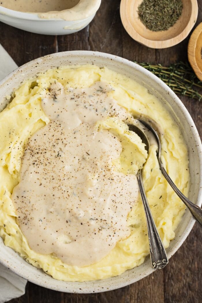 White gravy atop a large bowl of mashed potatoes