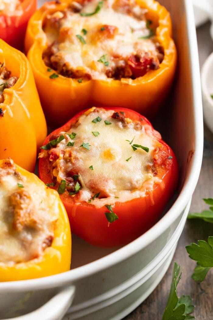 keto stuffed peppers in a baking dish with fresh parsley