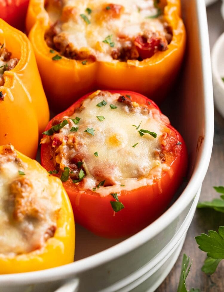 keto stuffed peppers in a baking dish with fresh parsley