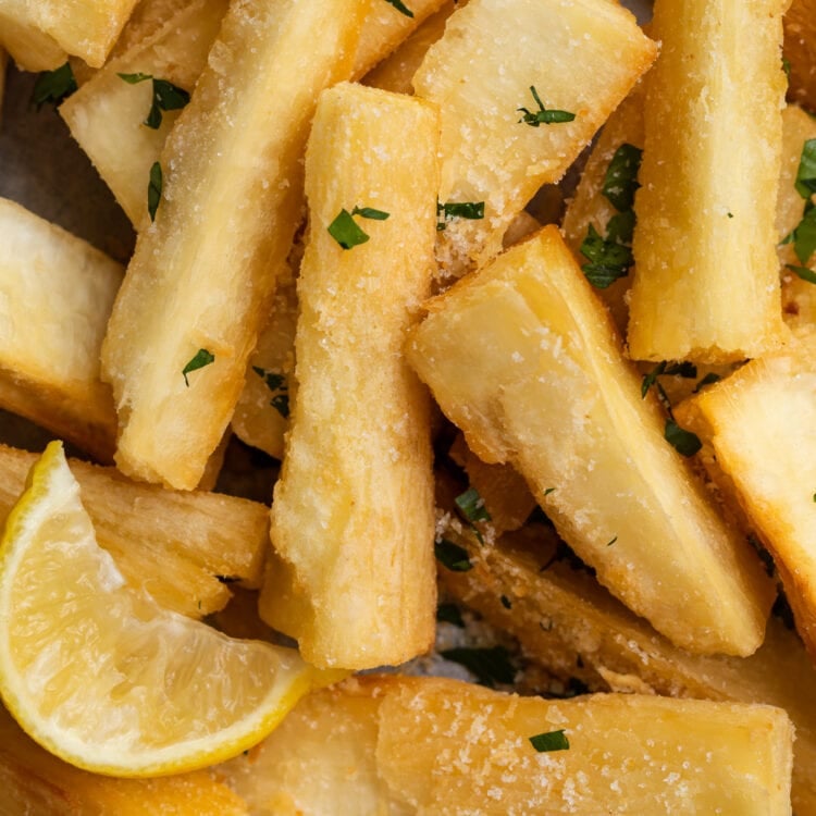 close-up image of yucca fries with a lemon wedge
