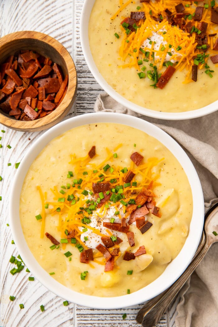 Overhead view of two bowls of vegan potato soup on a table