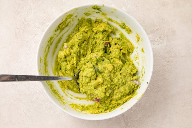 Quick guacamole in small bowl with spoon