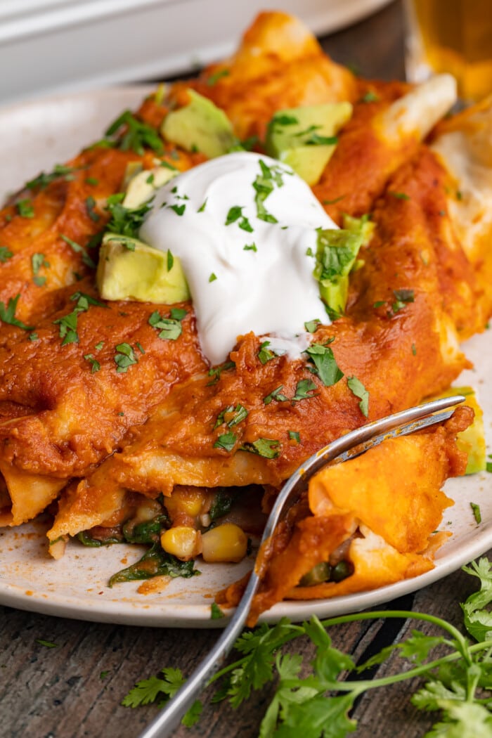 vegan enchiladas on a plate with a fork
