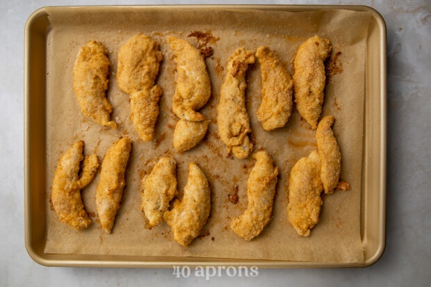 Baked Whole30 chicken tenders on baking sheet lined with parchment paper