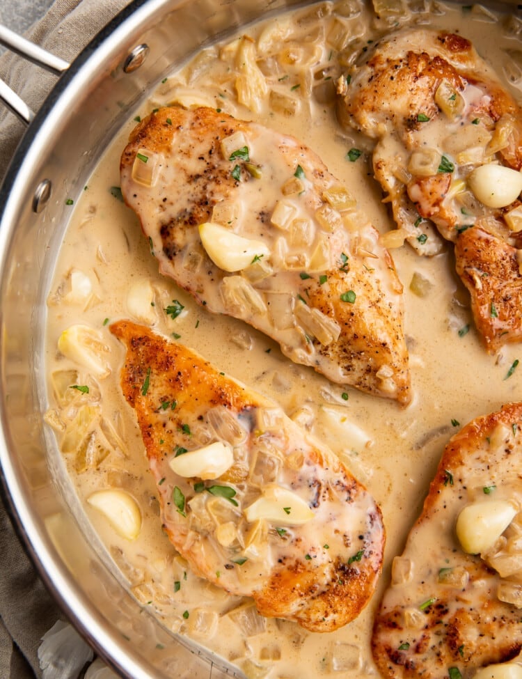 Overhead view of Whole30 creamy garlic chicken in a large silver skillet.