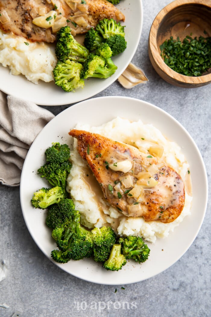 Whole30 creamy garlic chicken on a plate with mashed potatoes and broccoli.