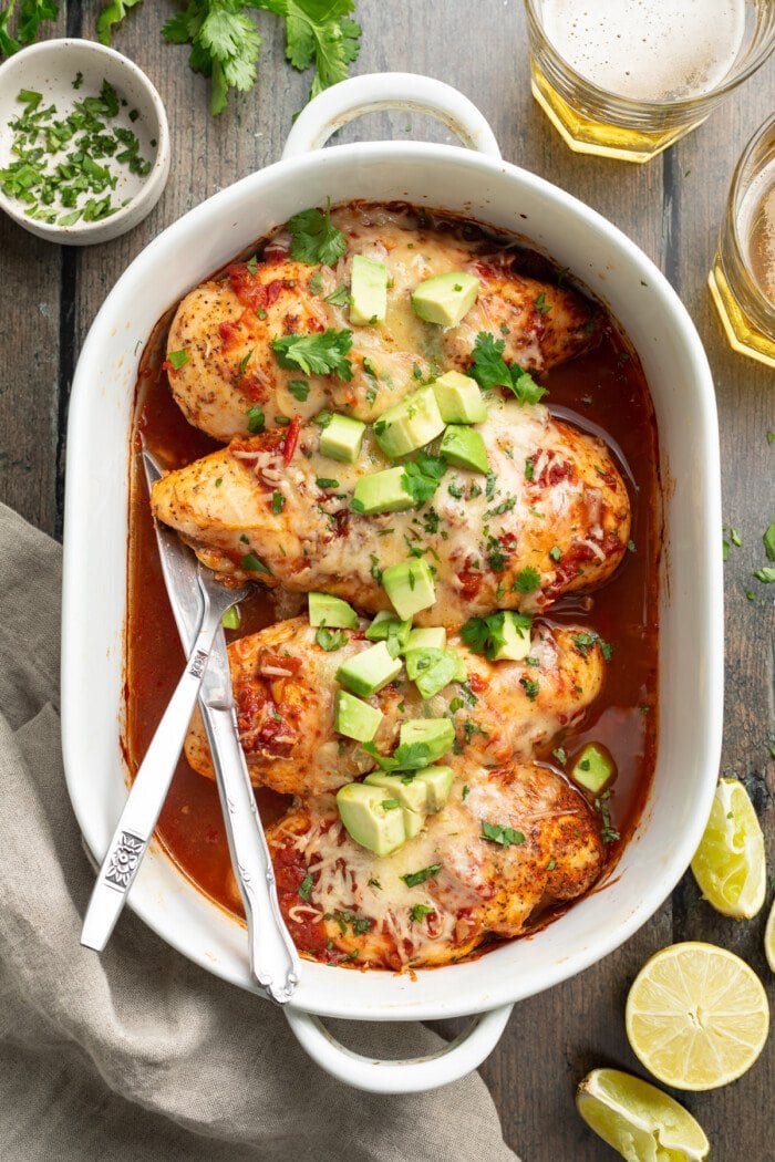 overhead image of salsa chicken in a baking dish with cilantro and avocado on top