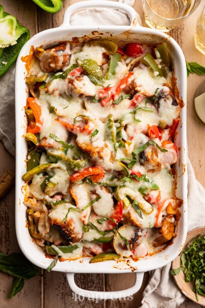 Overhead view of cheesy Italian sausage and bell pepper casserole in a white casserole dish.