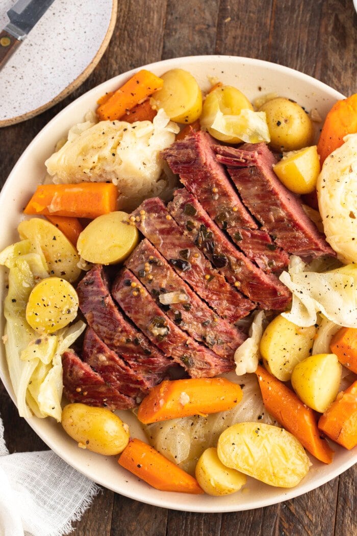 Overhead view of Instant Pot corned beef and cabbage on a round white platter