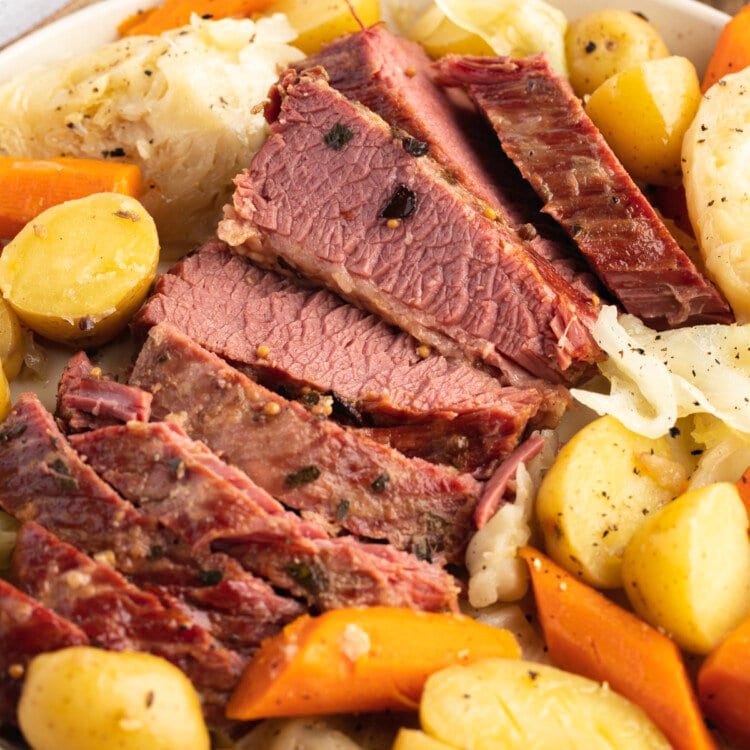 Overhead angled photo of sliced Instant Pot corned beef and cabbage with potatoes and carrots.