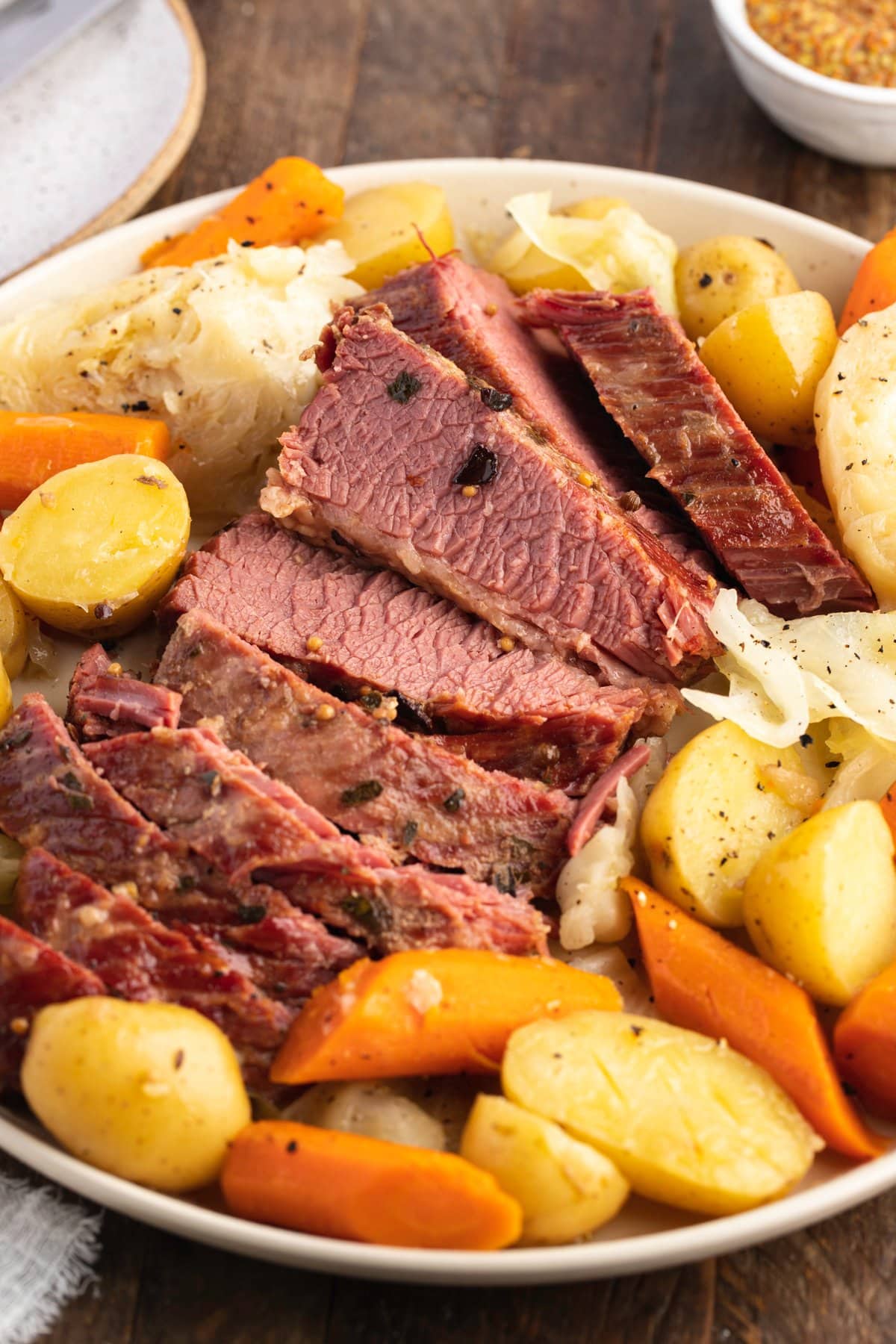 Overhead angled photo of sliced Instant Pot corned beef and cabbage with potatoes and carrots.
