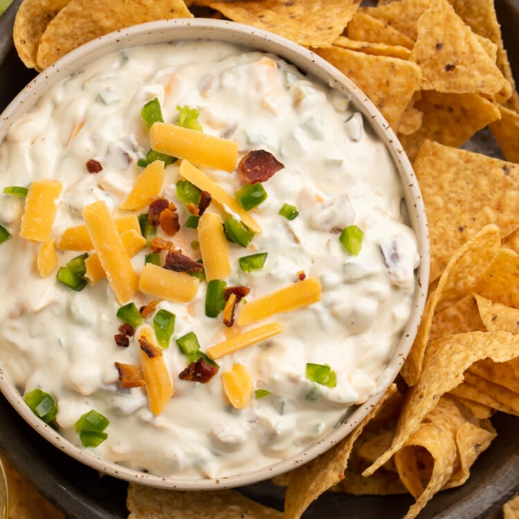 Overhead view of a bowl of jalapeno popper dip and tortilla chips.