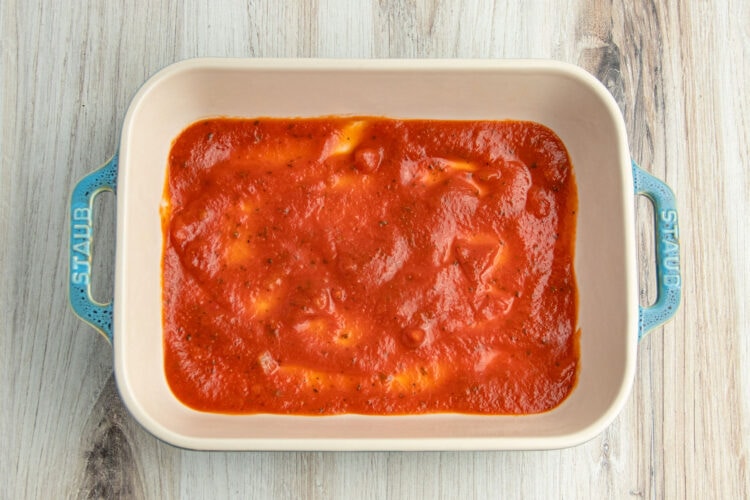 Keto-friendly red marinara sauce covering the bottom of a 9x13 baking dish.