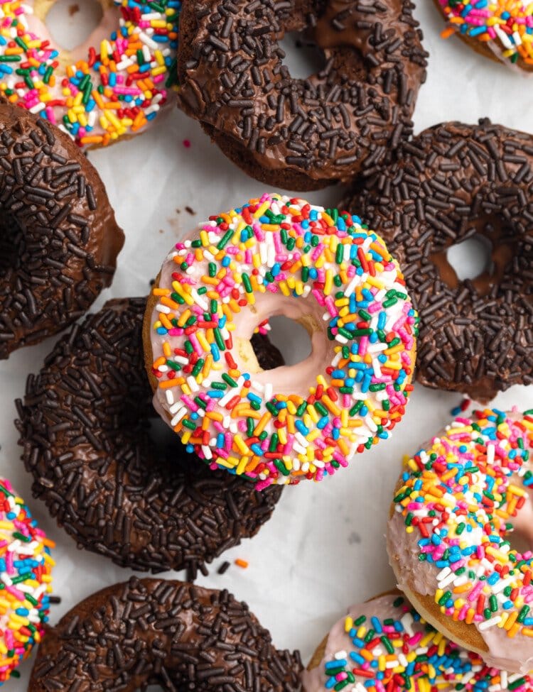 Overhead view of a mix of chocolate and vanilla gluten-free sprinkled donuts.