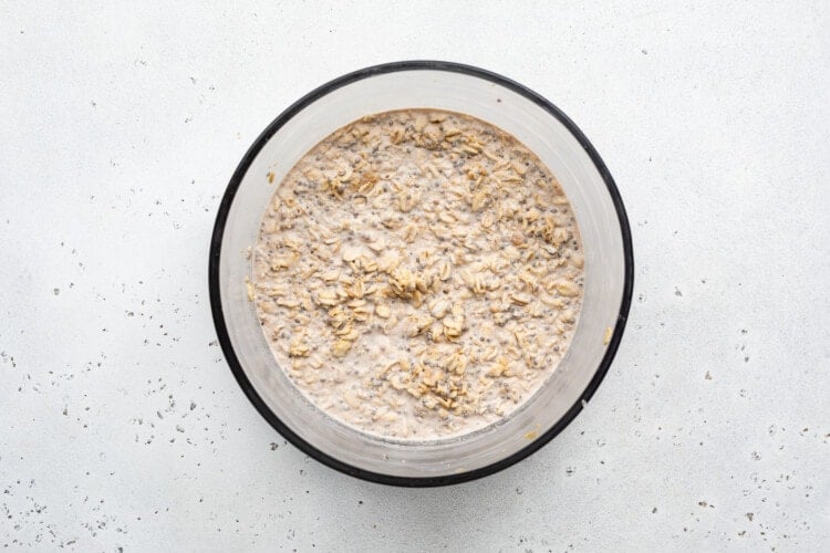 Overhead view of set peanut butter overnight oats in a large glass mixing bowl.