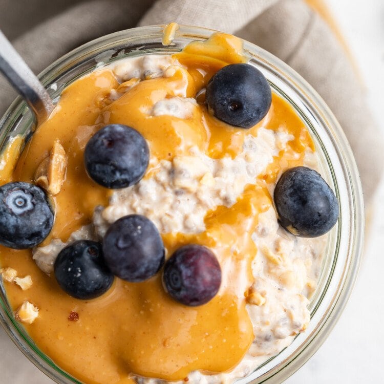 Overhead view of peanut butter overnight oats topped with peanut butter and blueberries.