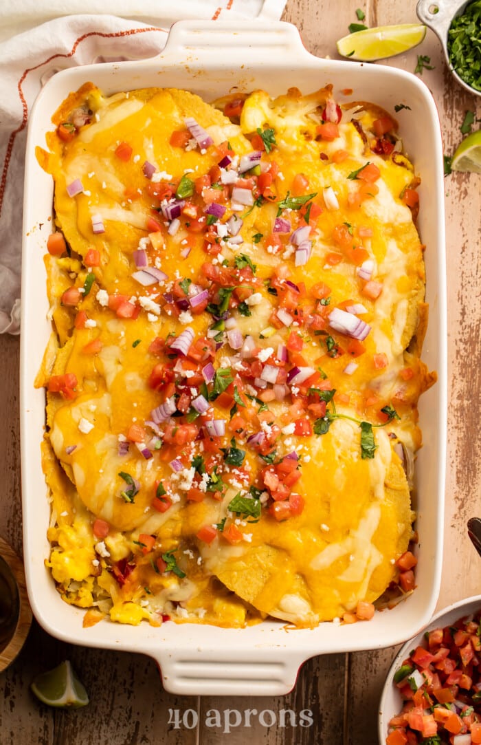 Overhead view of a baking dish containing breakfast taco casserole garnished with pico.