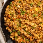 Overhead view of chicken fried rice in a large cast iron skillet.