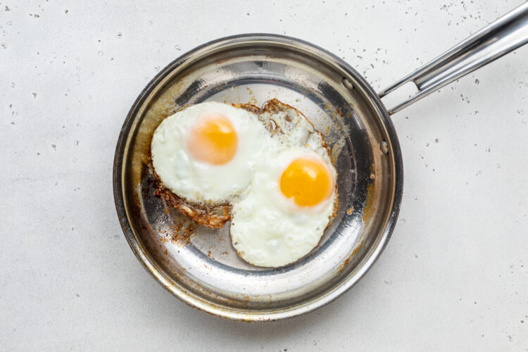 2 fried eggs in large silver skillet.