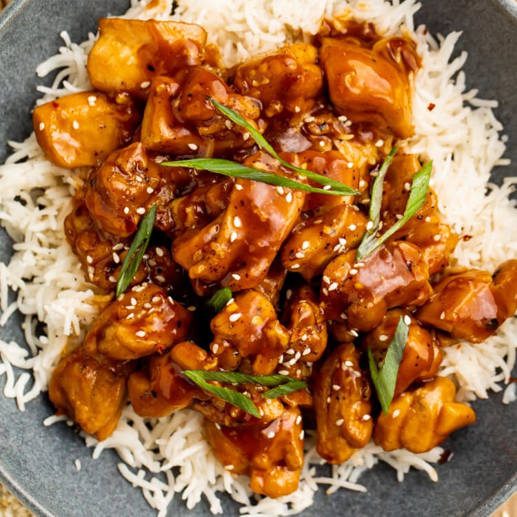 Close-up, overhead view of a bowl of Bourbon chicken on a bed of white rice.