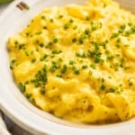 3/4-angle view of a bowl of boursin scrambled eggs garnished with chives.