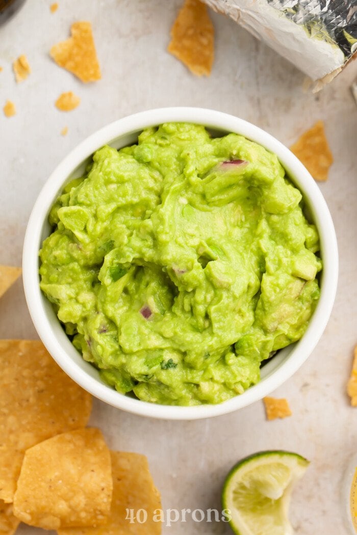 Close-up view of a ramekin with Chipotle guacamole surrounded by lime tortilla chips
