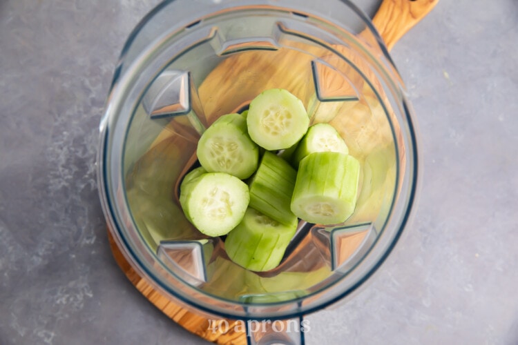 Peeled and chopped cucumbers in glass blender bowl.